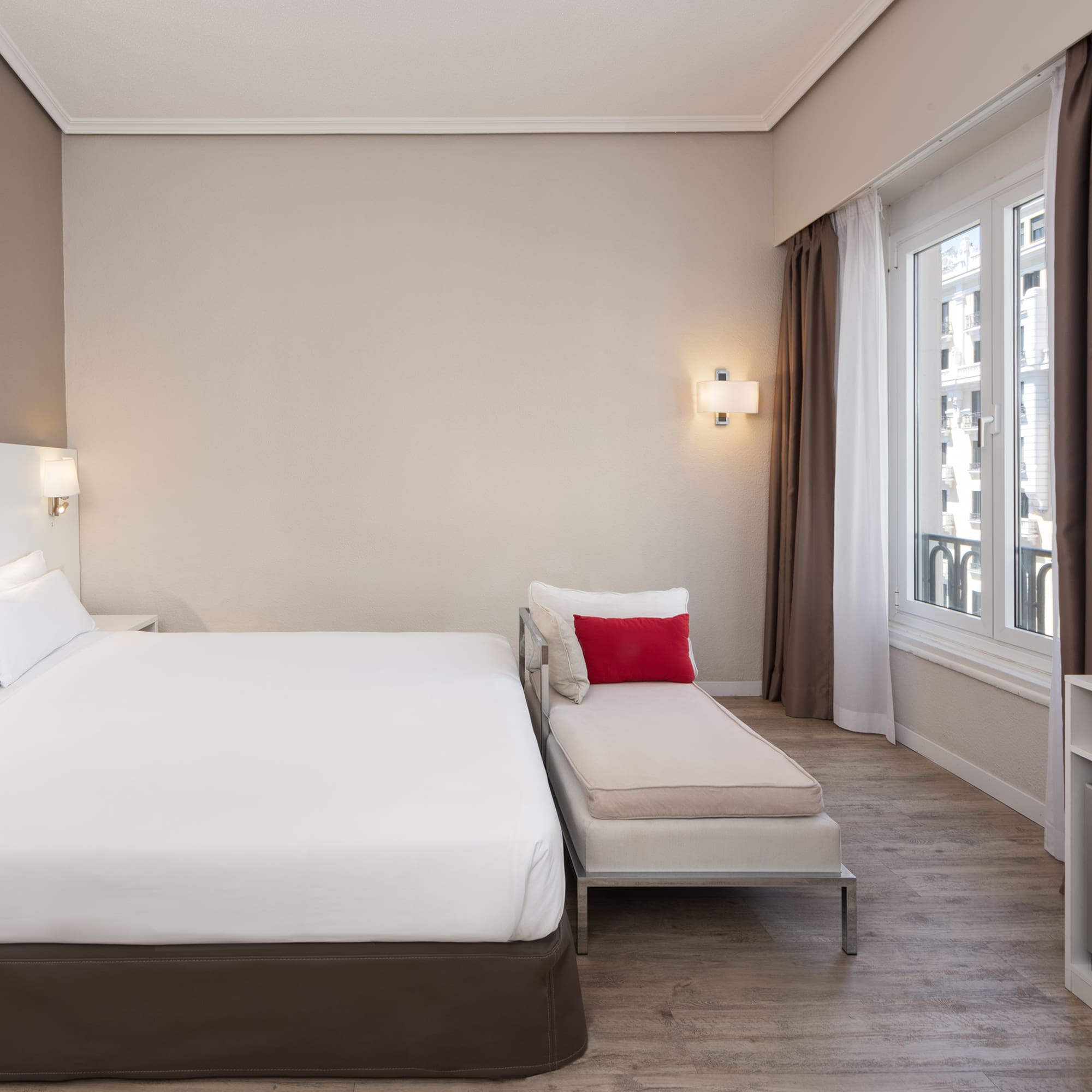 a bedroom with a bed and a chaise longue