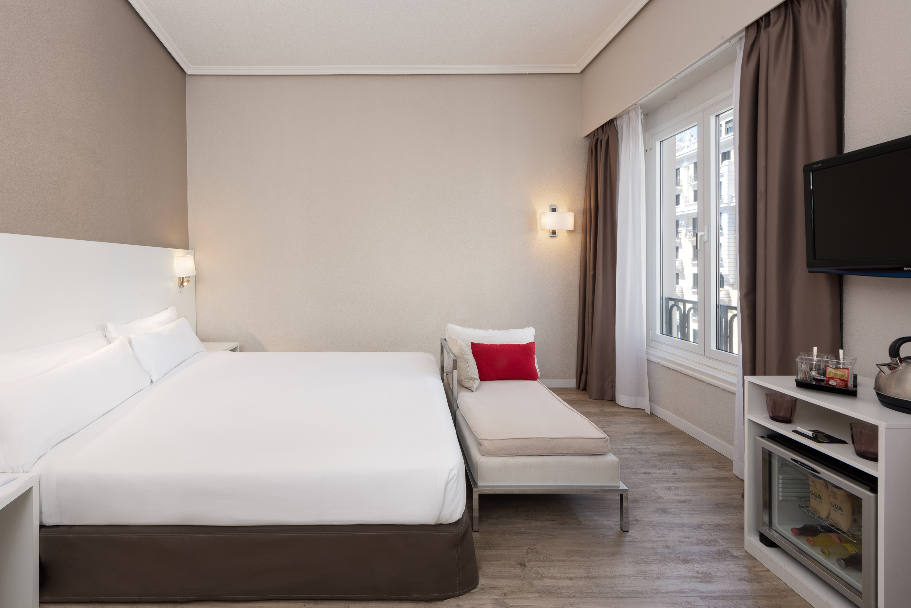 a bedroom with a bed and a chaise longue