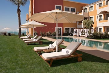 a pool with lounge chairs and umbrellas