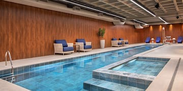 a indoor swimming pool with chairs and a bench