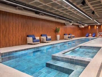 a indoor swimming pool with chairs and a bench