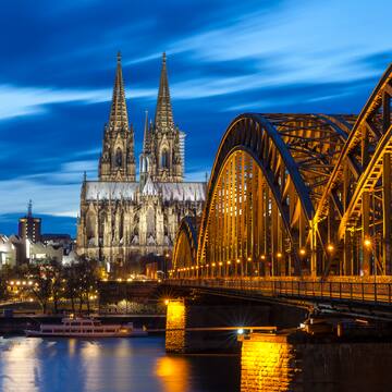 Cologne Cathedral over water with a bridge and a cathedral