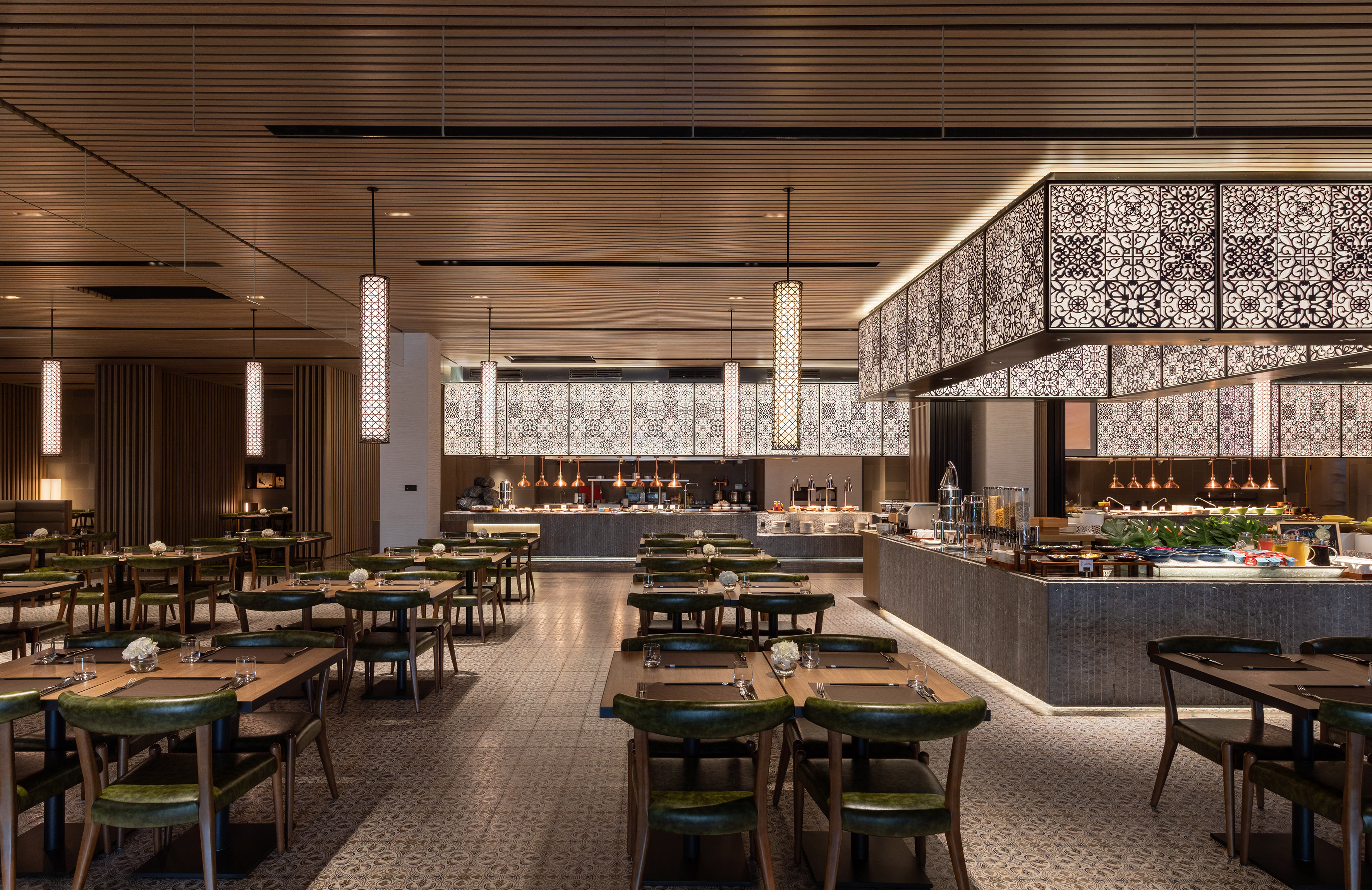 Elegant restaurant buffet with green chairs and patterned decor.