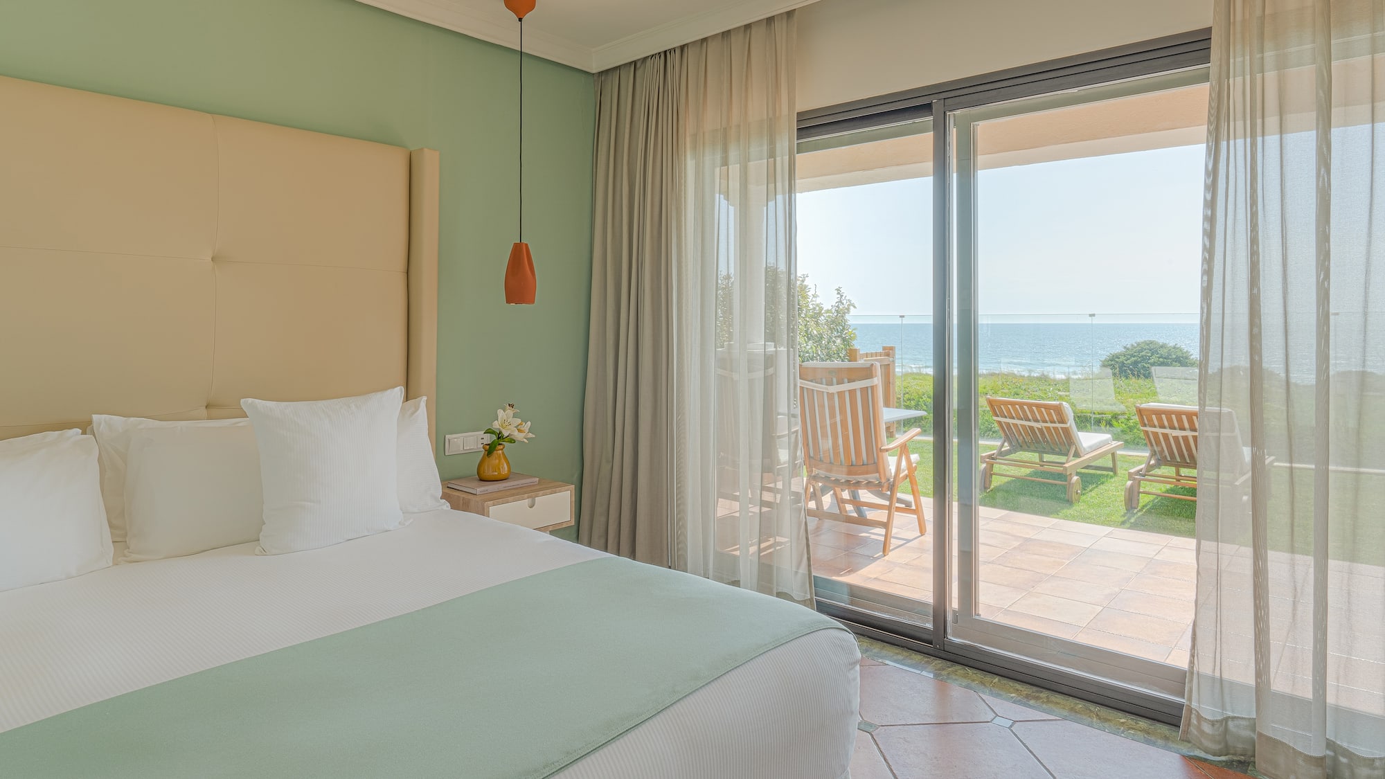 a bedroom with a large bed and a glass door