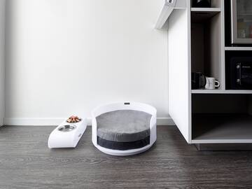a dog bed and a bowl in a room