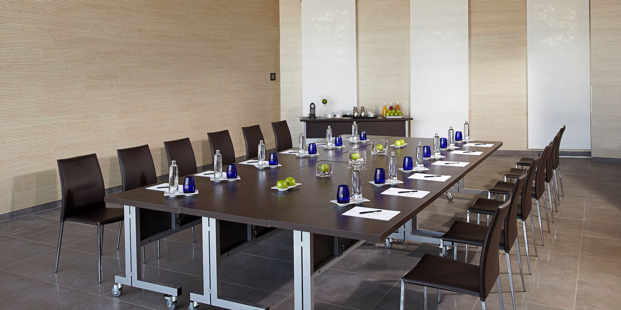 a conference room with a table with chairs and a table with a few objects on it