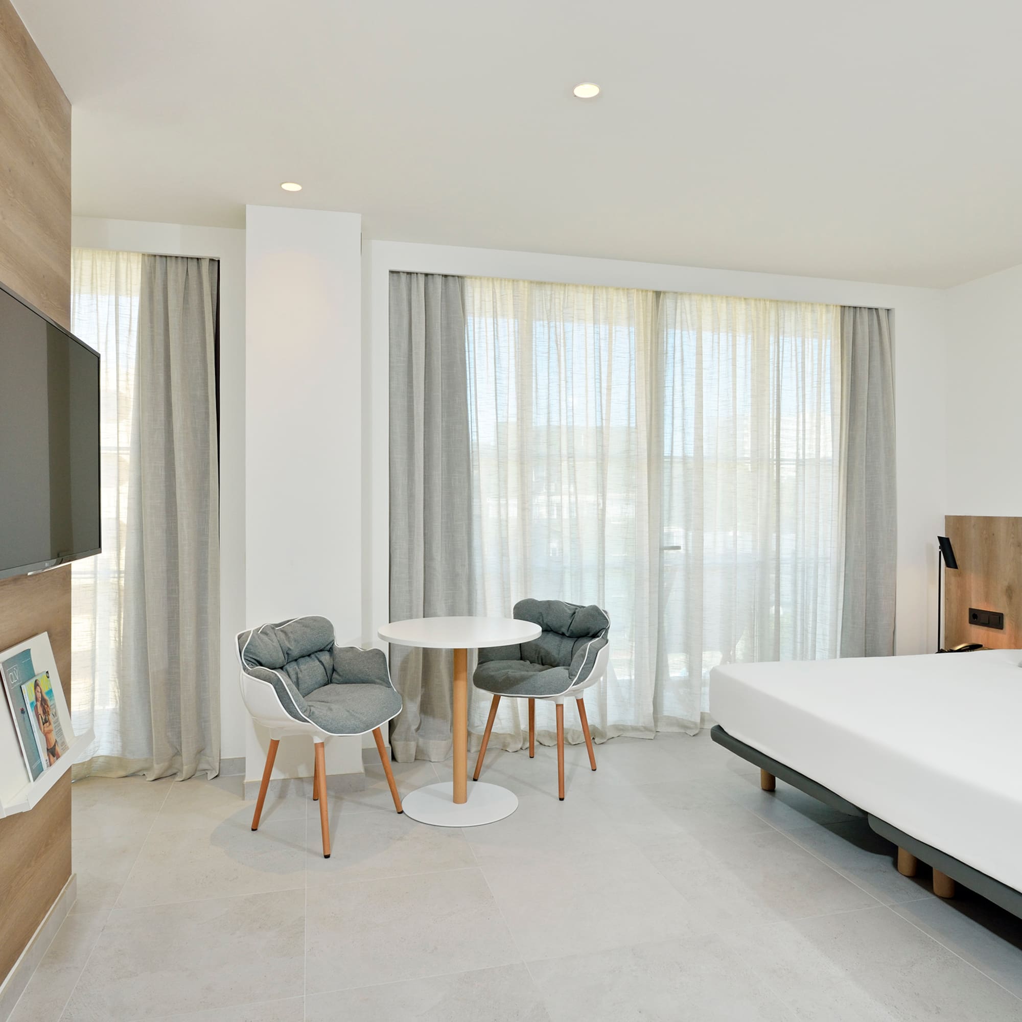 a room with a bed and a table and chairs