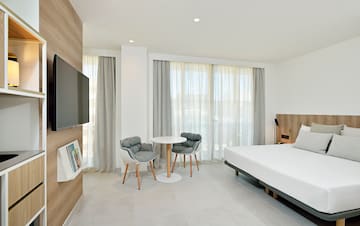 a room with a bed and a table and chairs