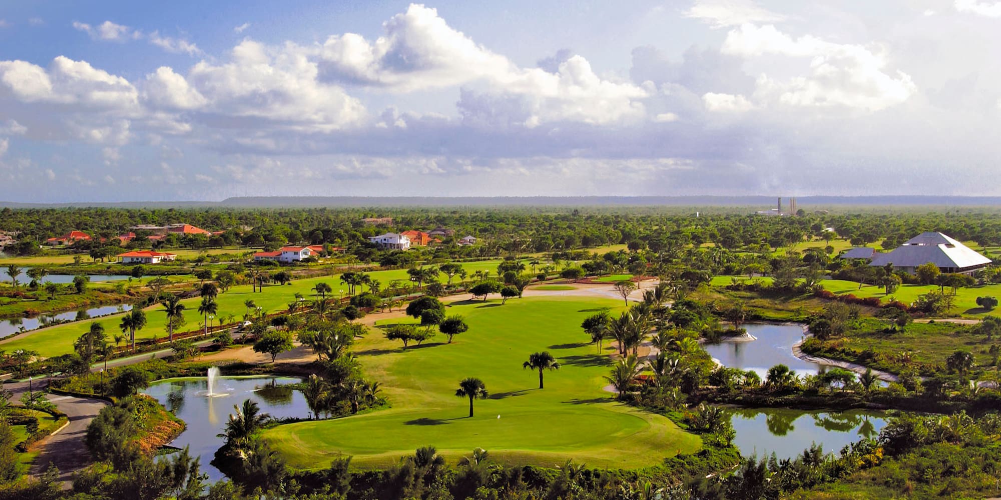a golf course with water and trees