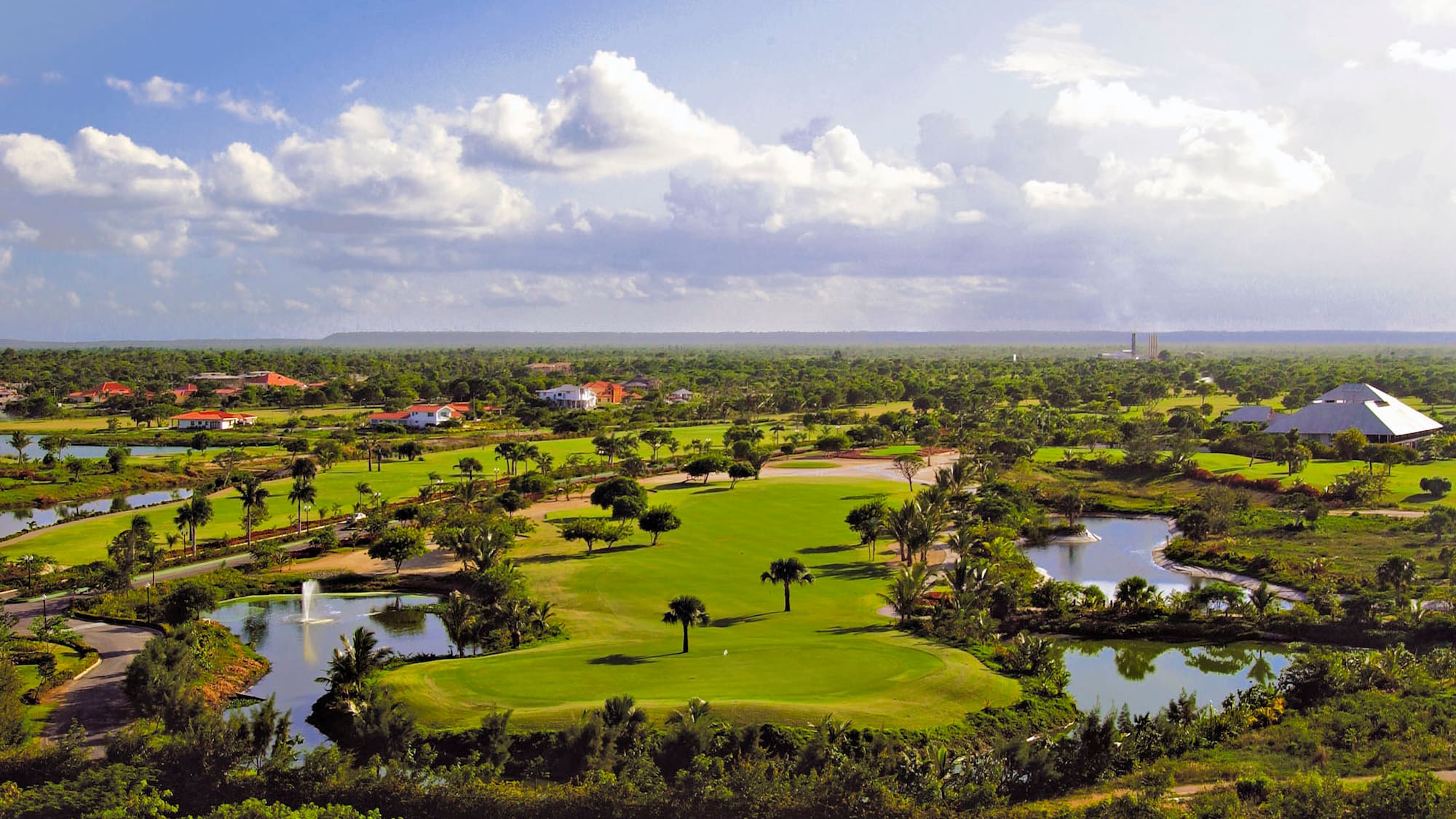 a golf course with water and trees