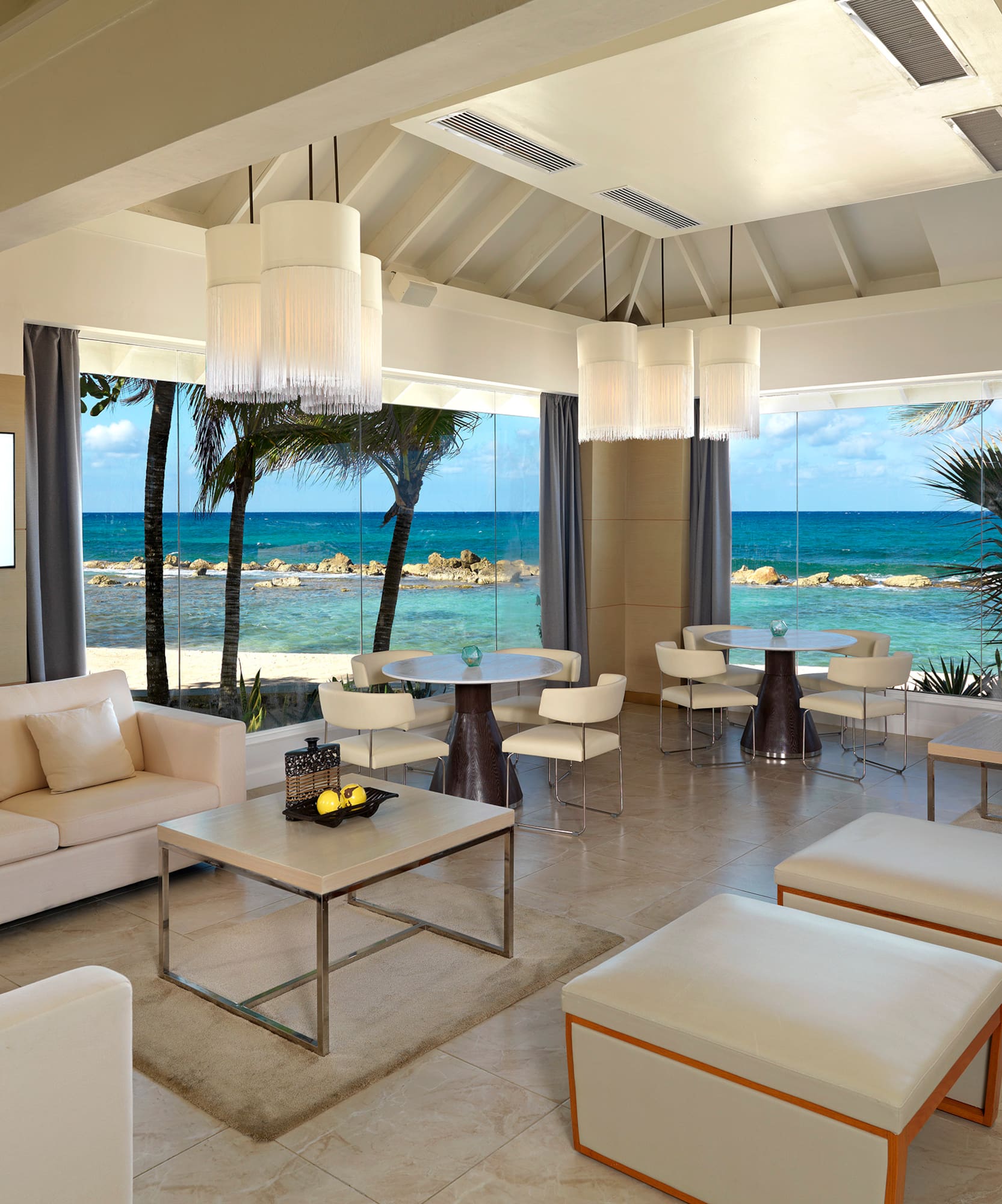 a room with white furniture and a view of the ocean