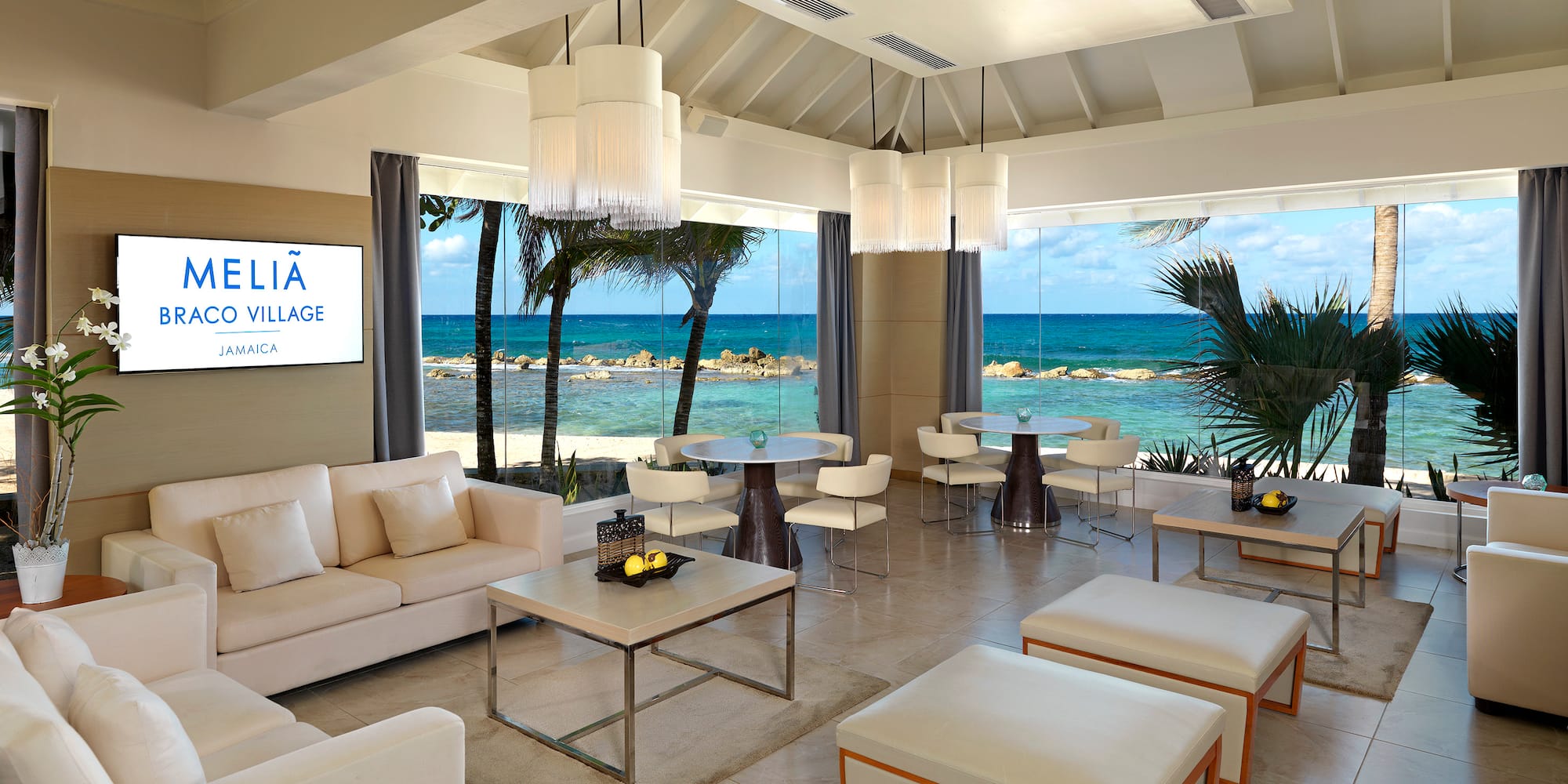 a room with white furniture and a view of the ocean