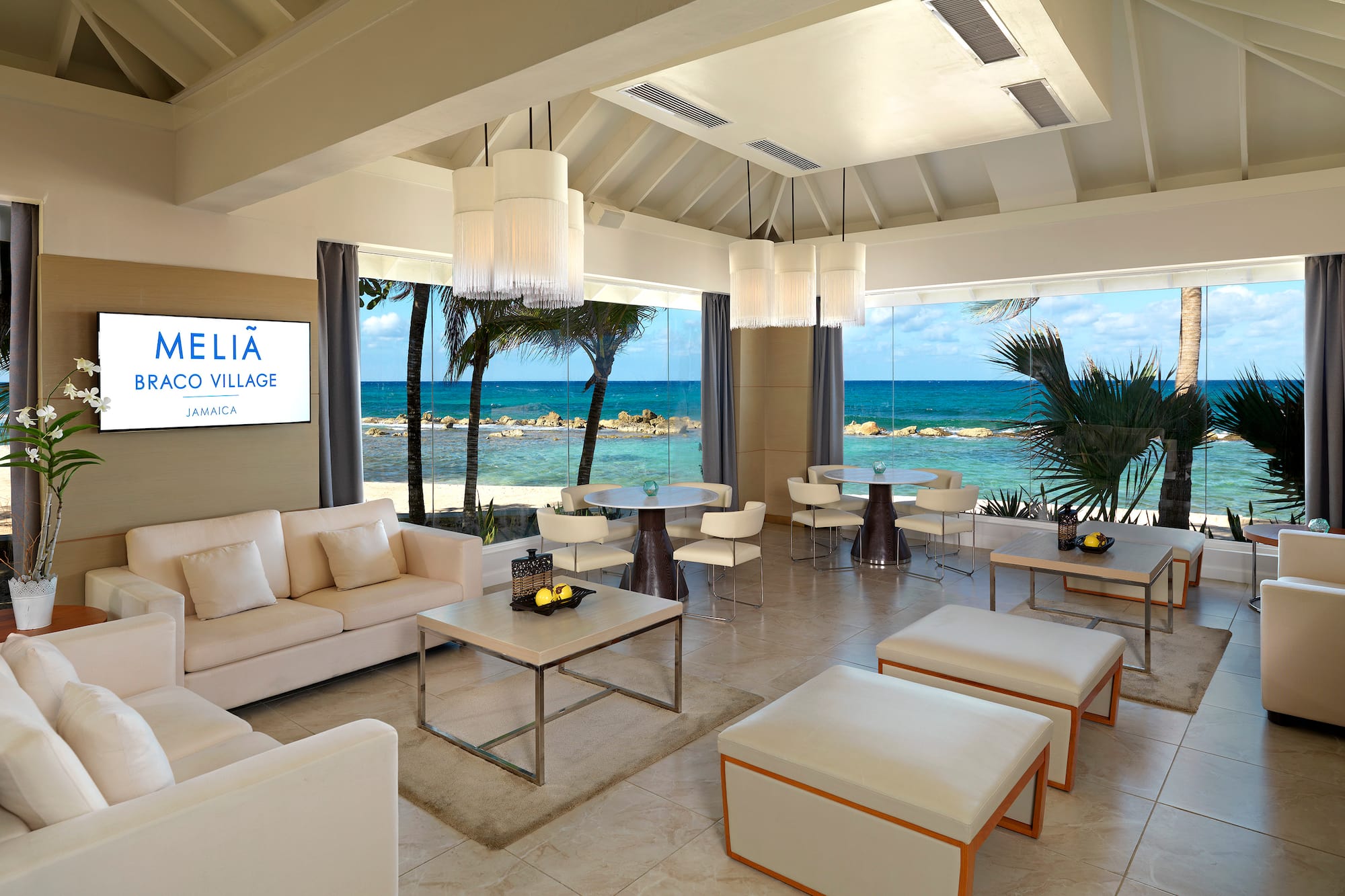 a room with white furniture and a view of the ocean