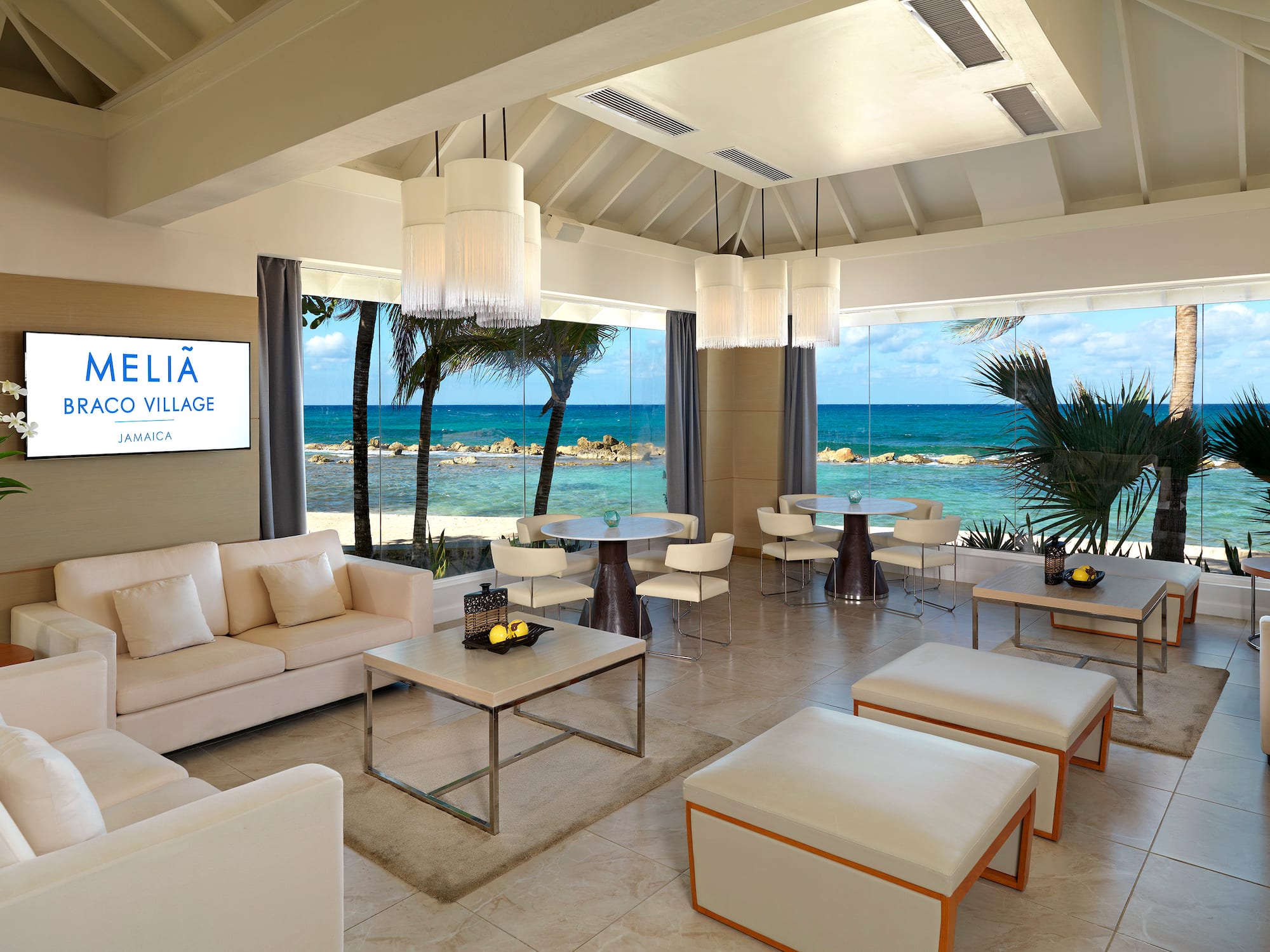 a room with white furniture and a view of the ocean