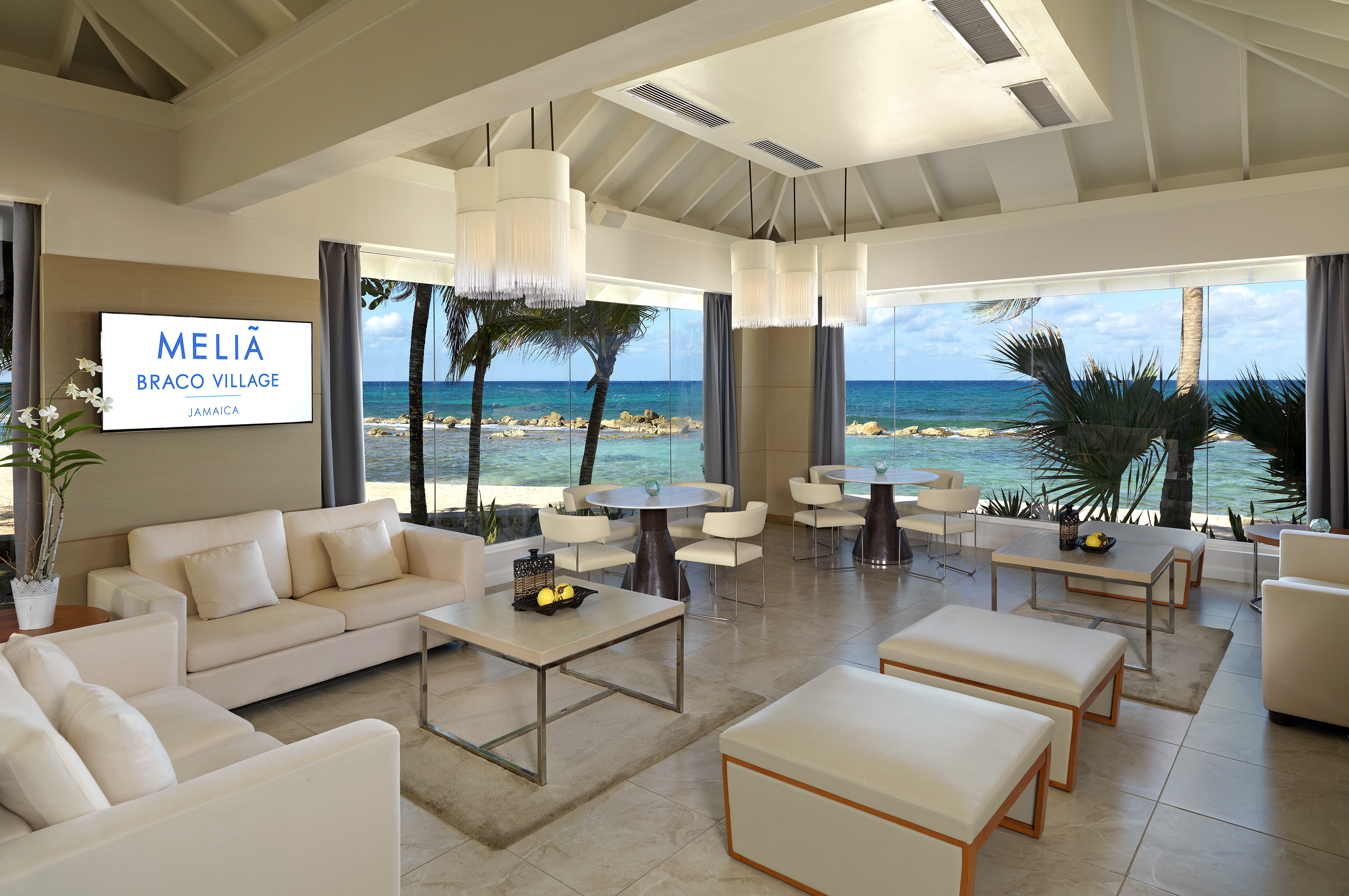 a room with white furniture and a view of the ocean