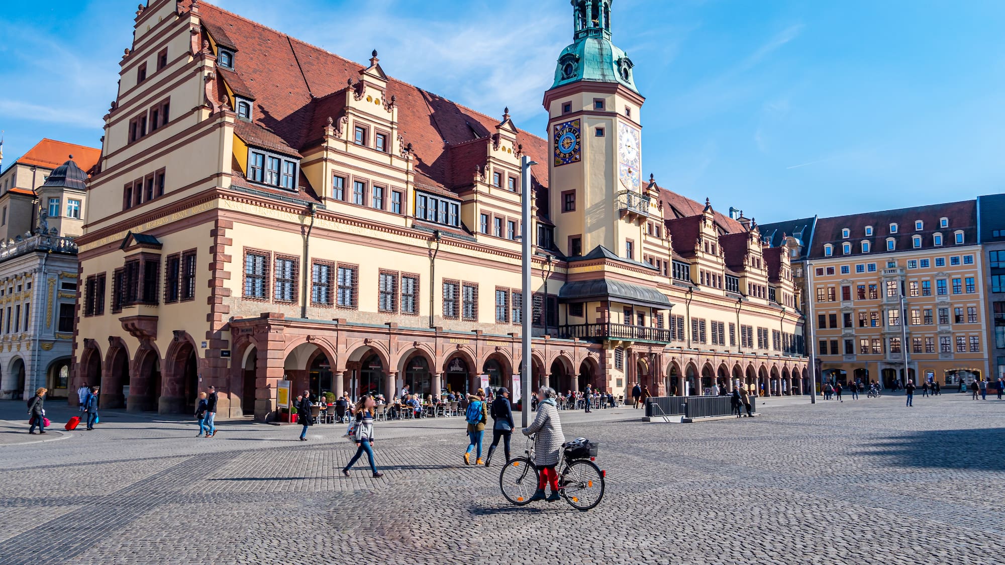 a large building with a clock tower and people walking around