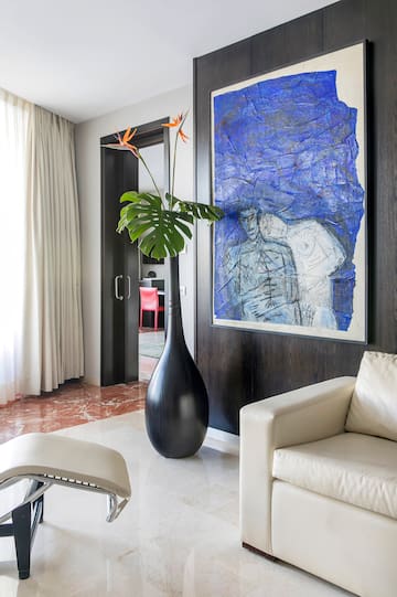 a large black vase next to a painting