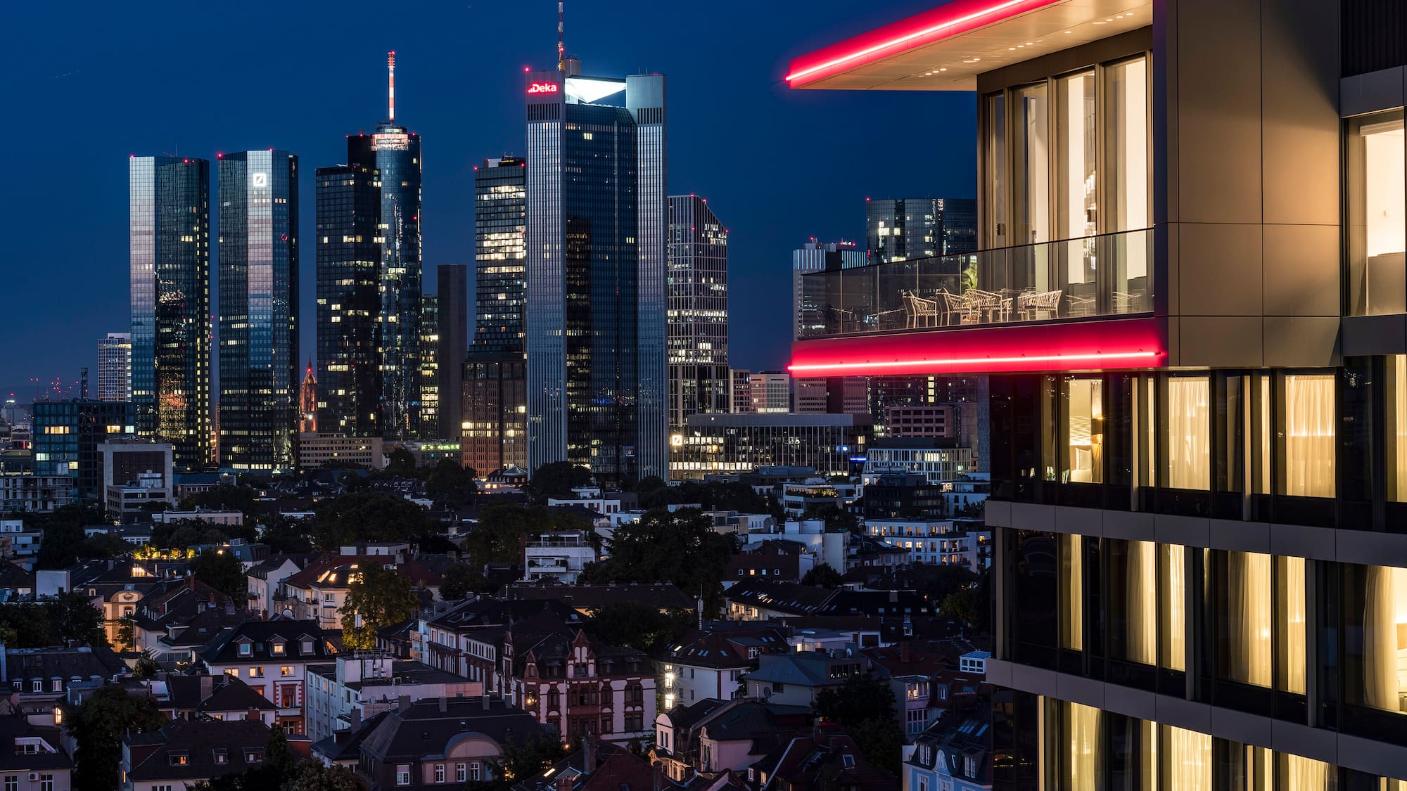a city skyline with a balcony and a red light