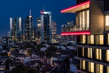 a city skyline with a balcony and a red light