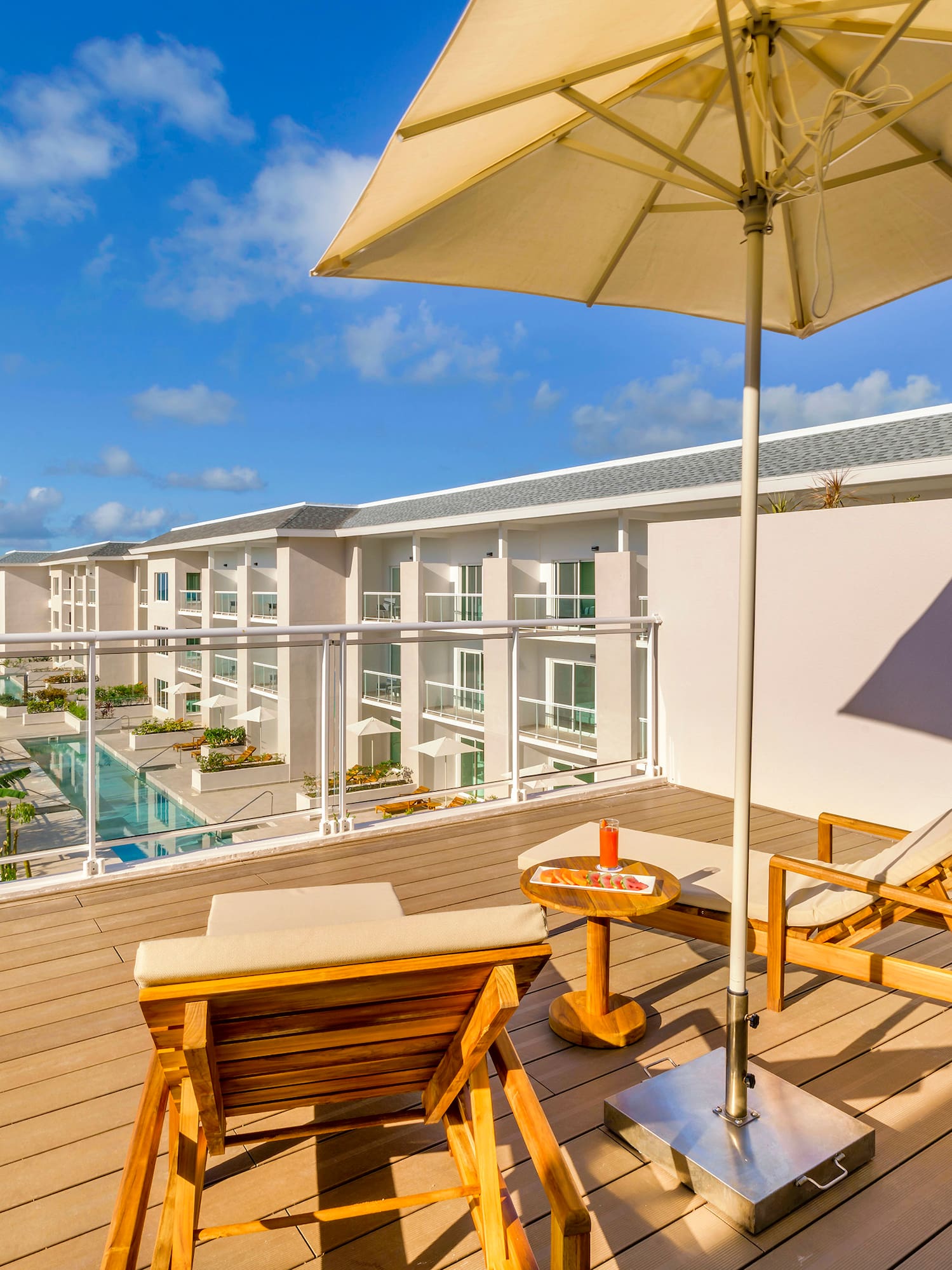 a deck with chairs and umbrella on a sunny day