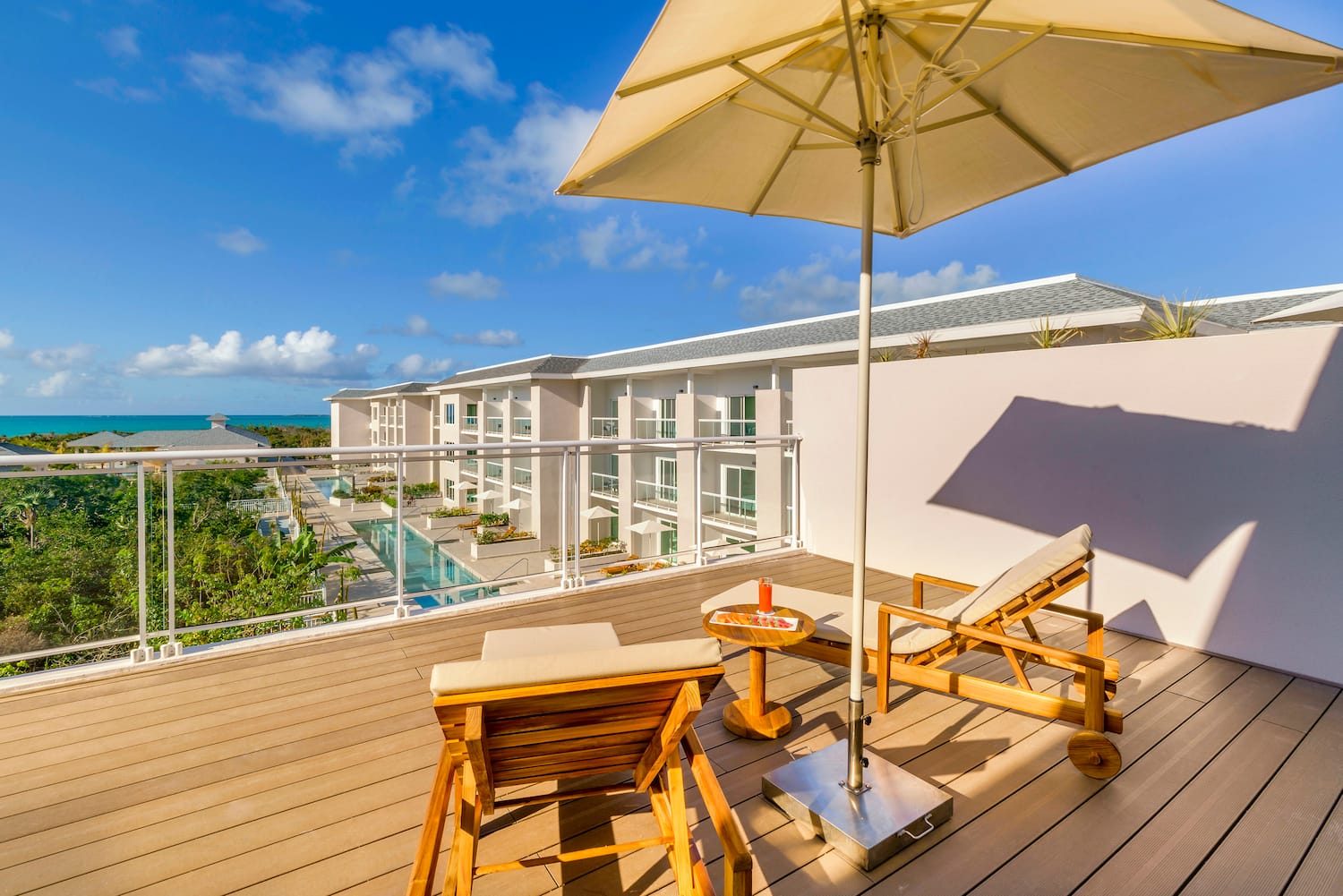 a deck with chairs and umbrella on a sunny day