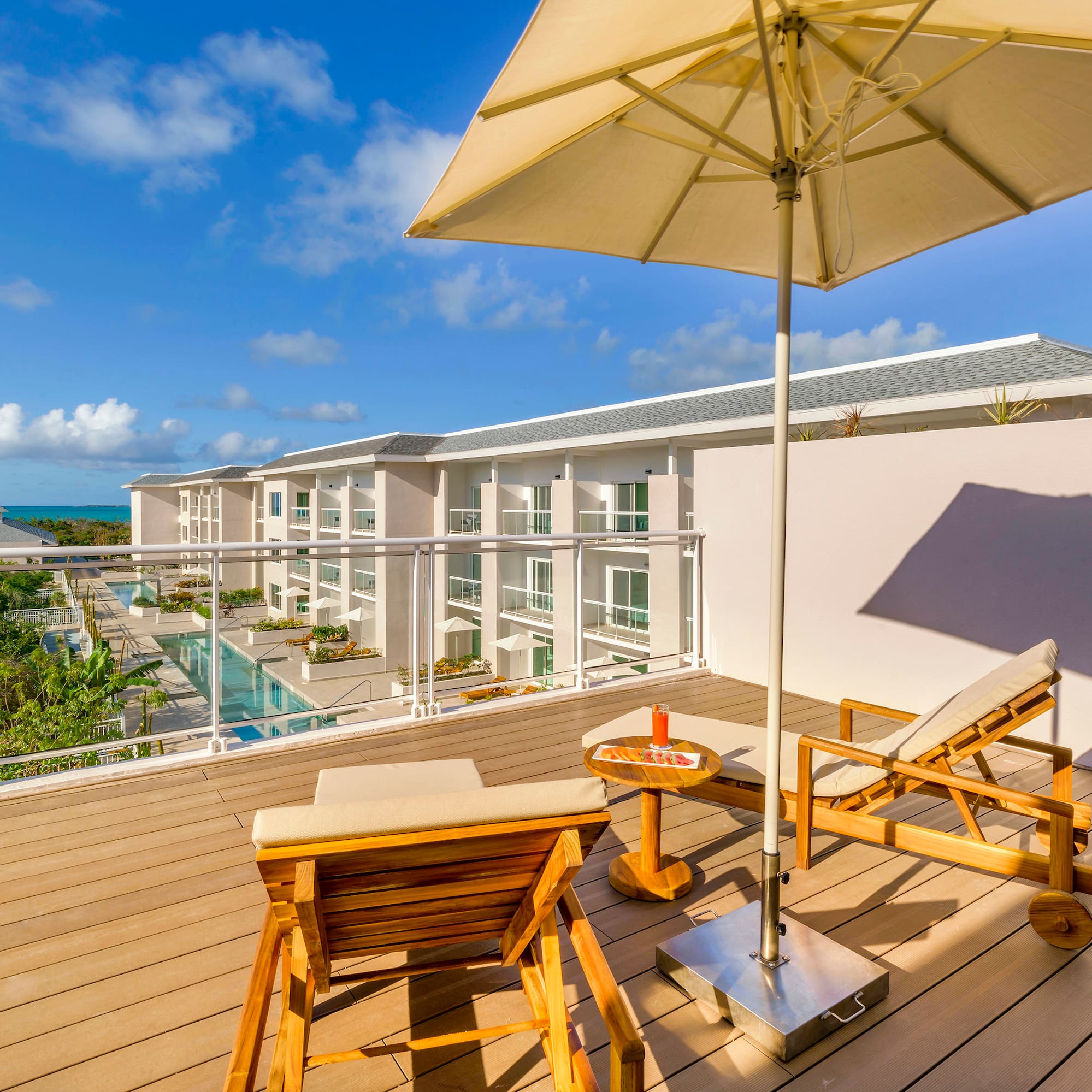 a deck with chairs and umbrella on a sunny day