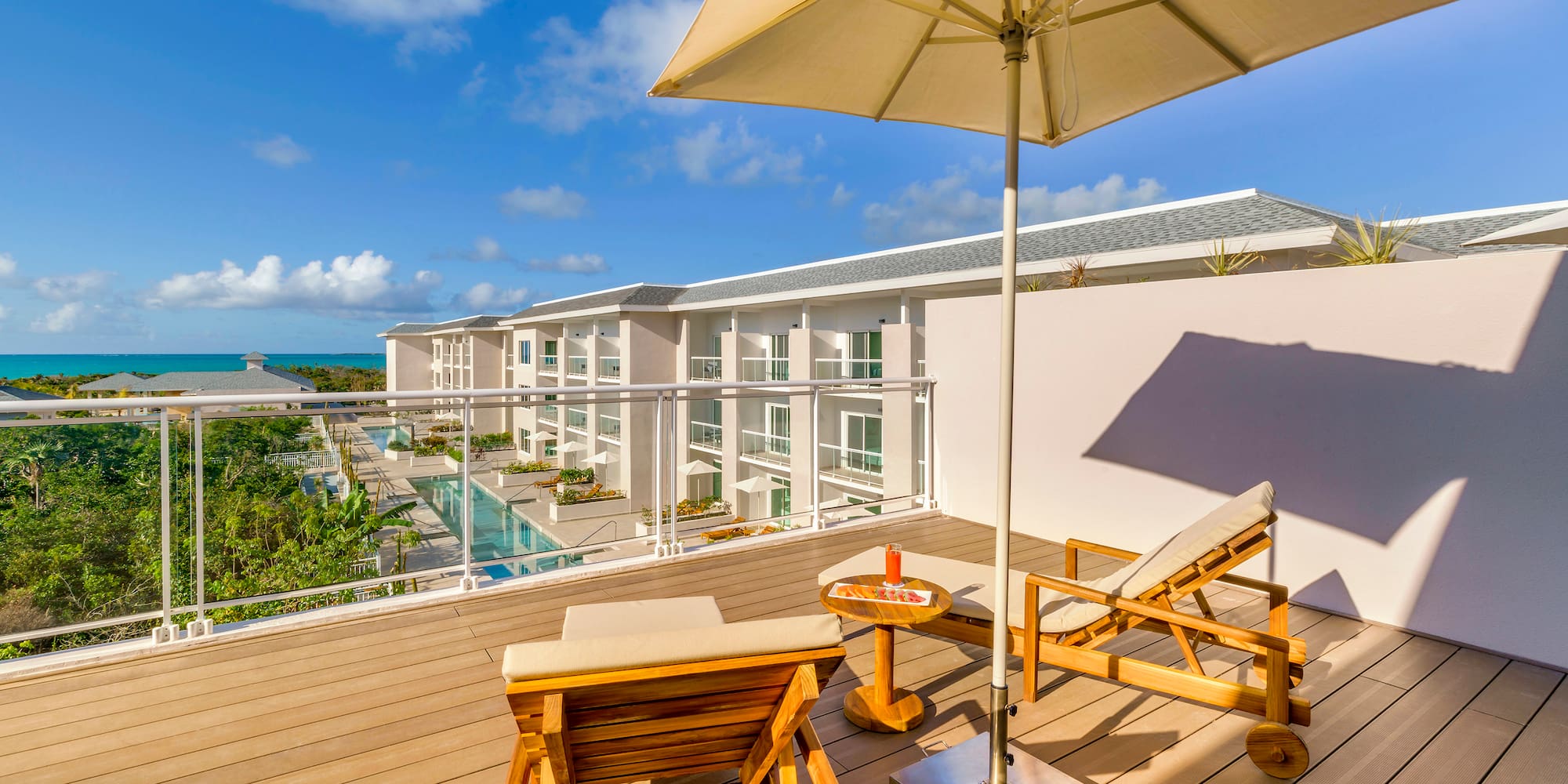 a deck with chairs and umbrella on a sunny day