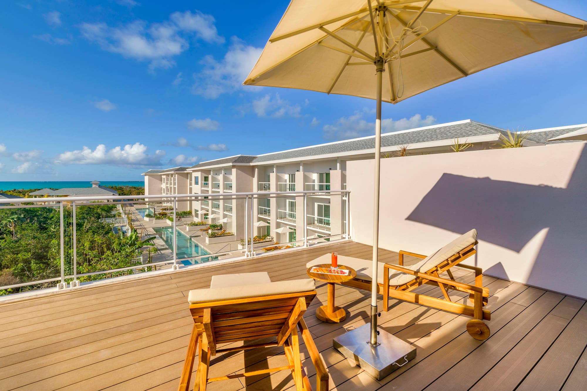a deck with chairs and umbrella on a sunny day