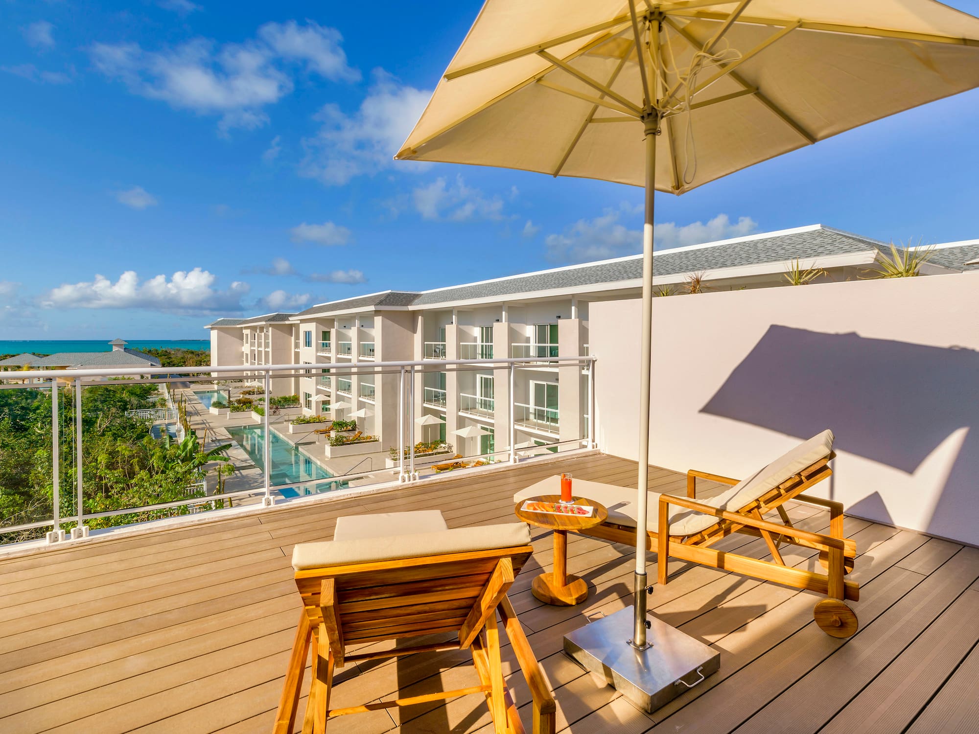 a deck with chairs and umbrella on a sunny day