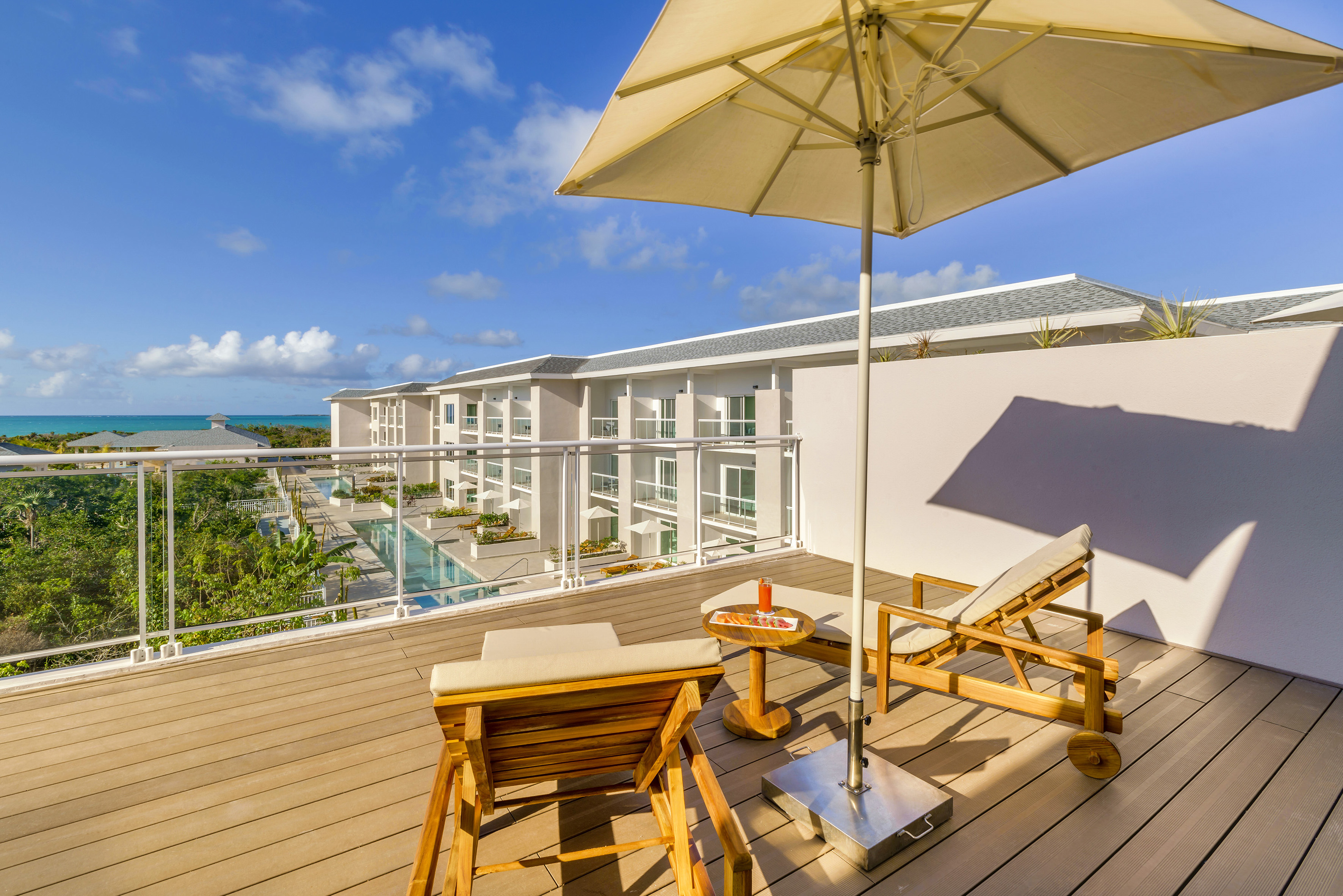 a deck with chairs and umbrella on a sunny day
