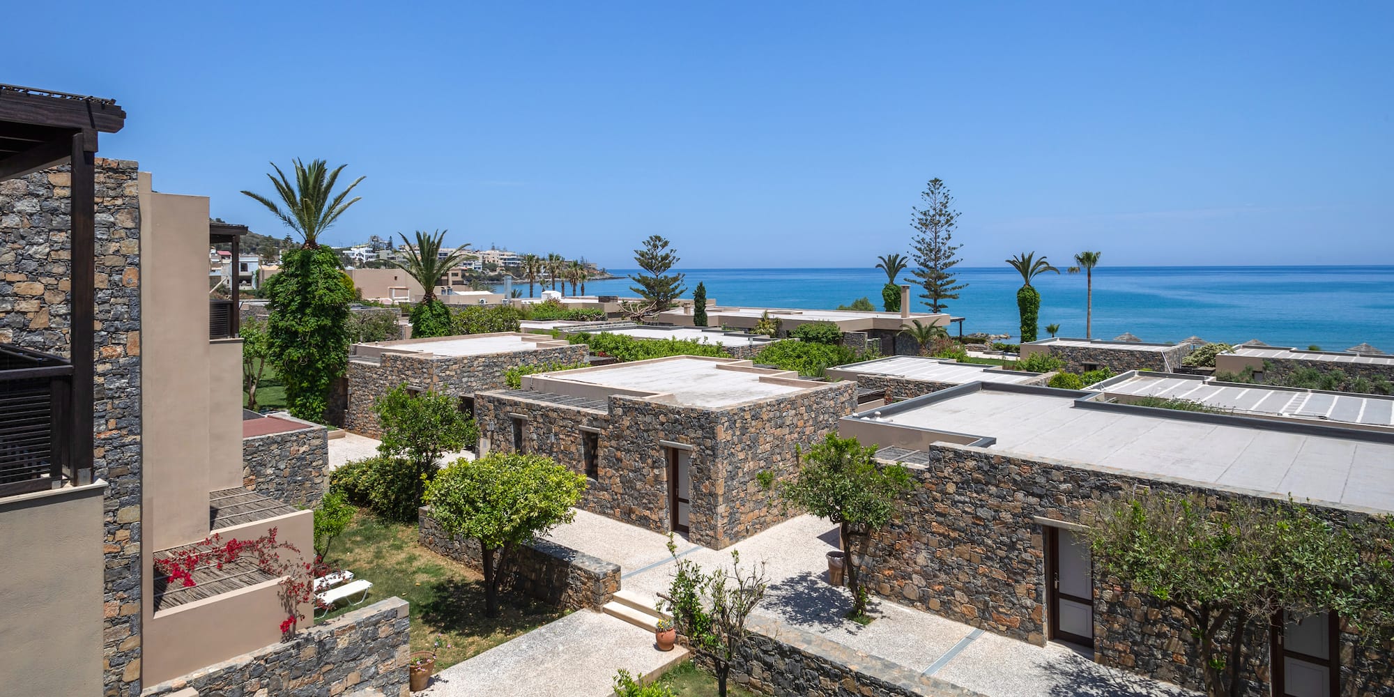 a group of buildings with trees and a body of water