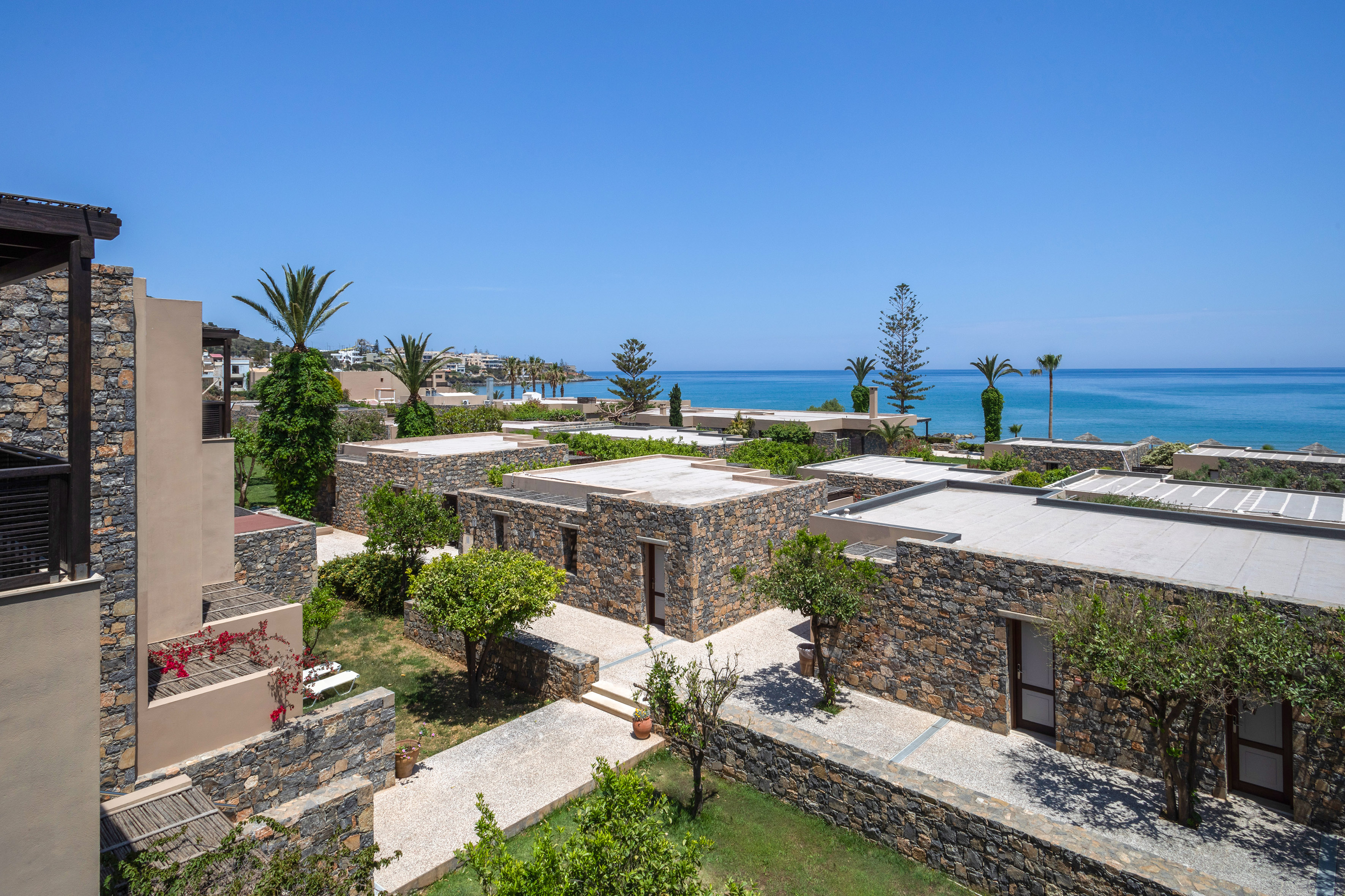 a group of buildings with trees and a body of water