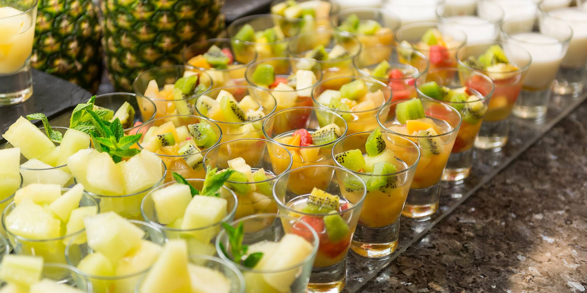 a group of glasses of fruit in a row