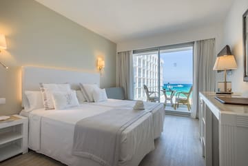 a hotel room with a view of the ocean and a beach