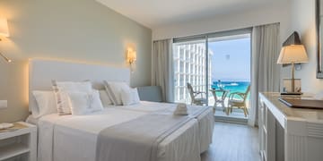 a hotel room with a view of the ocean and a beach