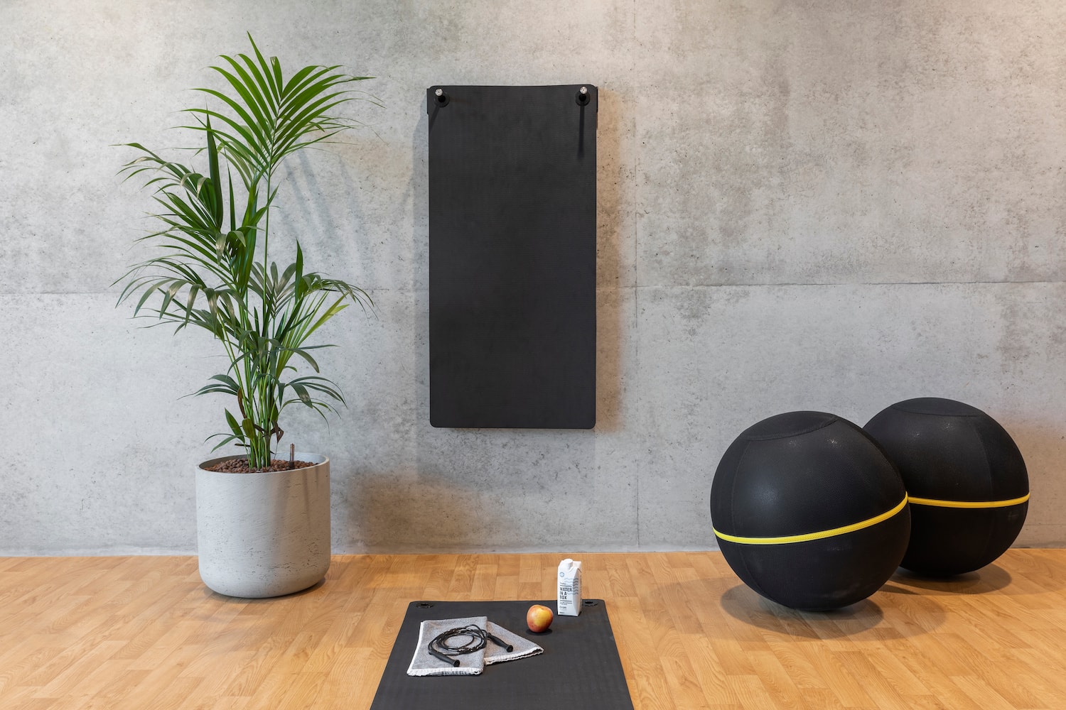 a yoga mat and exercise balls on a wooden floor
