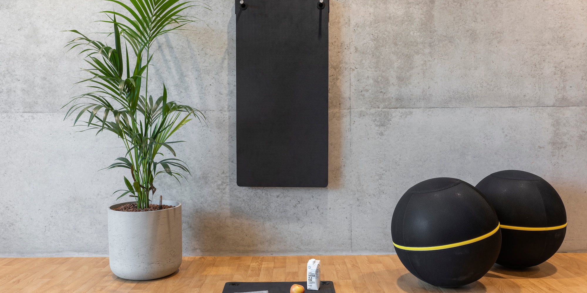 a yoga mat and exercise balls on a wooden floor