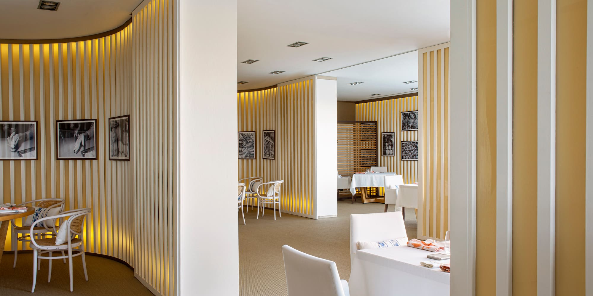 a room with white chairs and tables