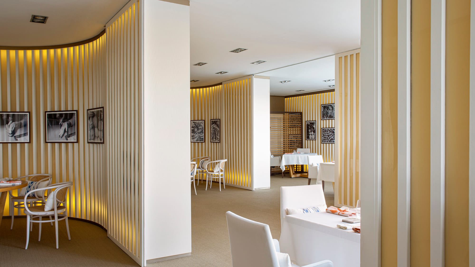 a room with white chairs and tables