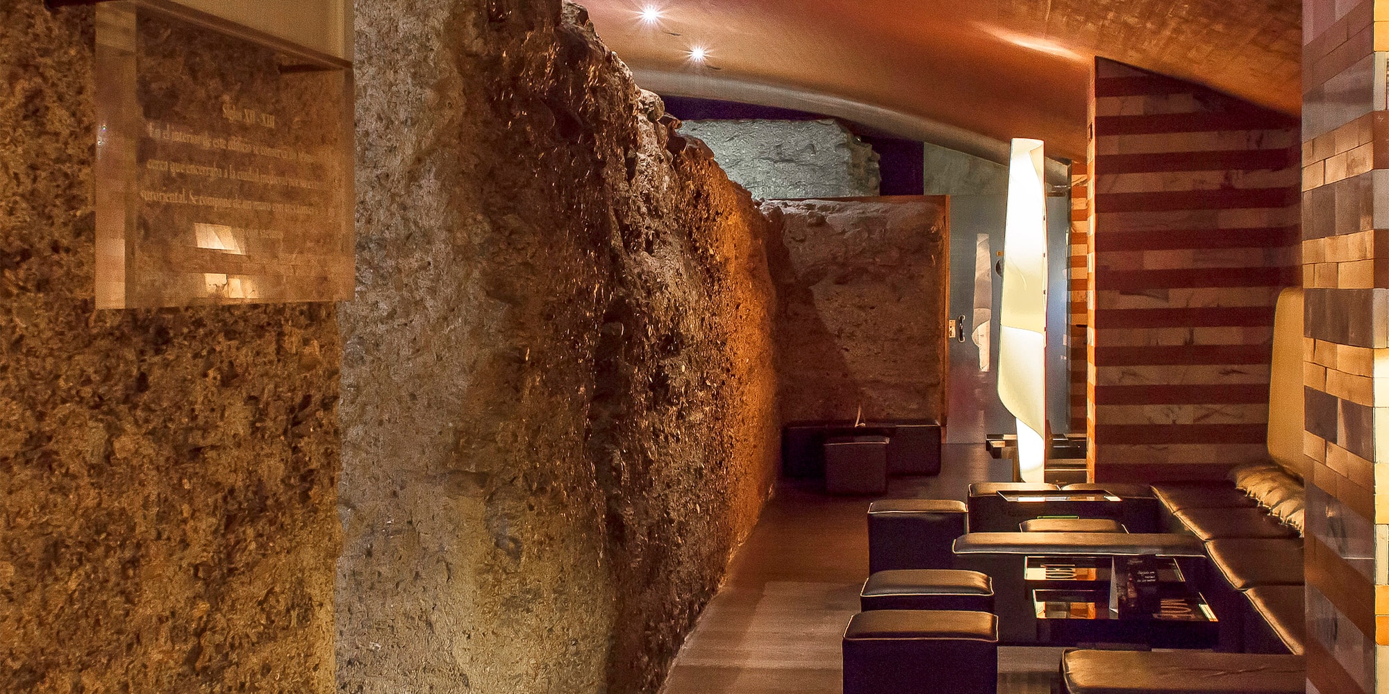 a stone wall with tables and chairs