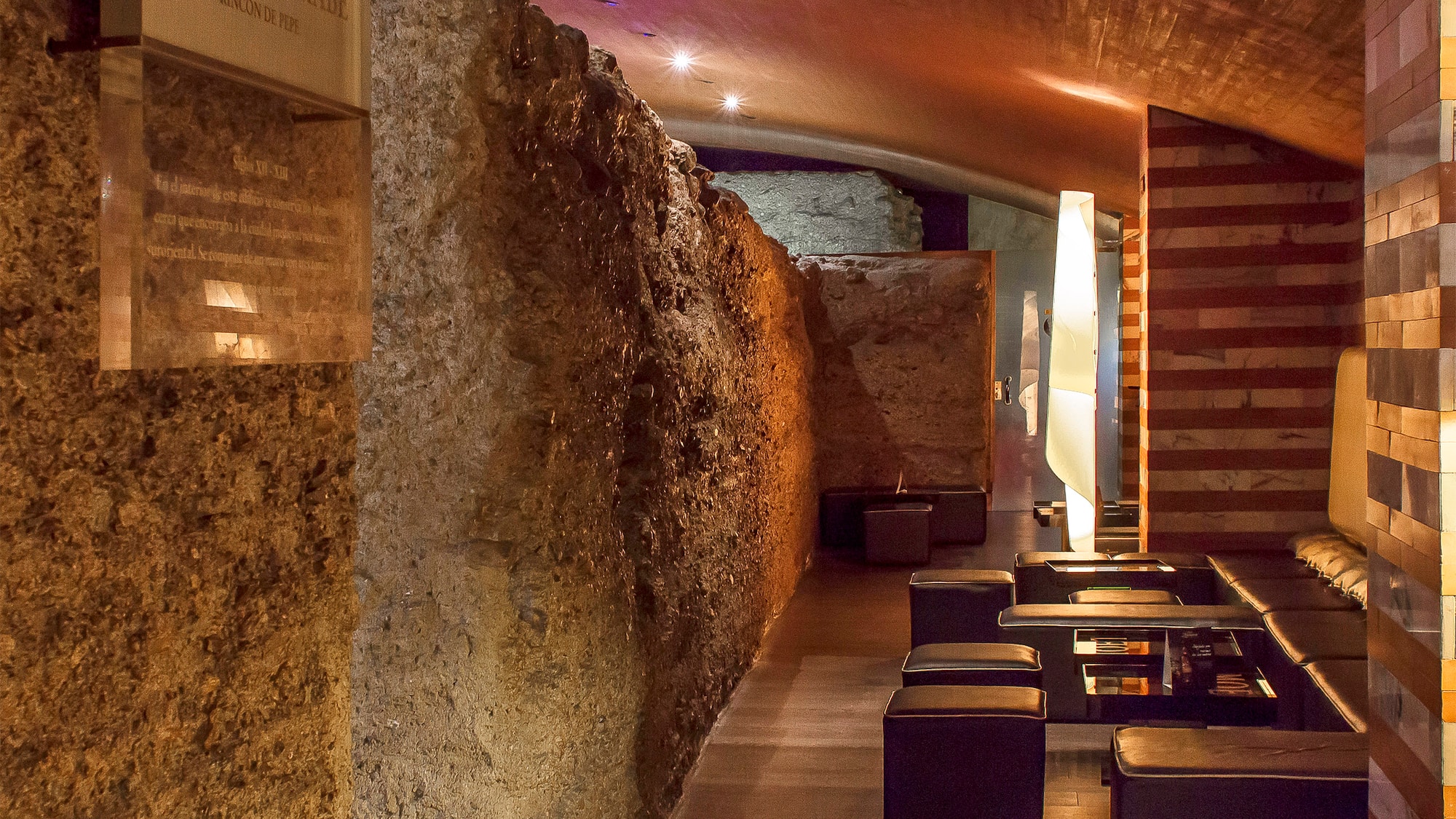 a stone wall with tables and chairs