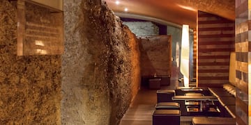 a stone wall with tables and chairs