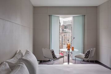 a room with a bed and chairs
