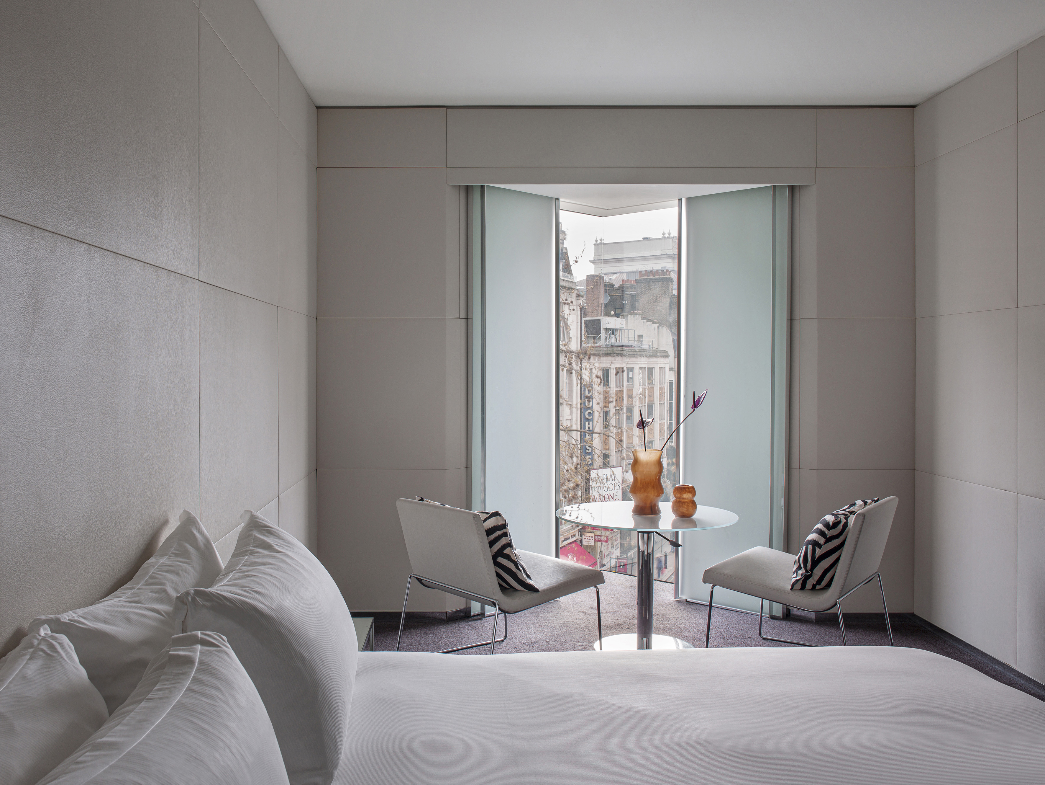 a room with a bed and chairs