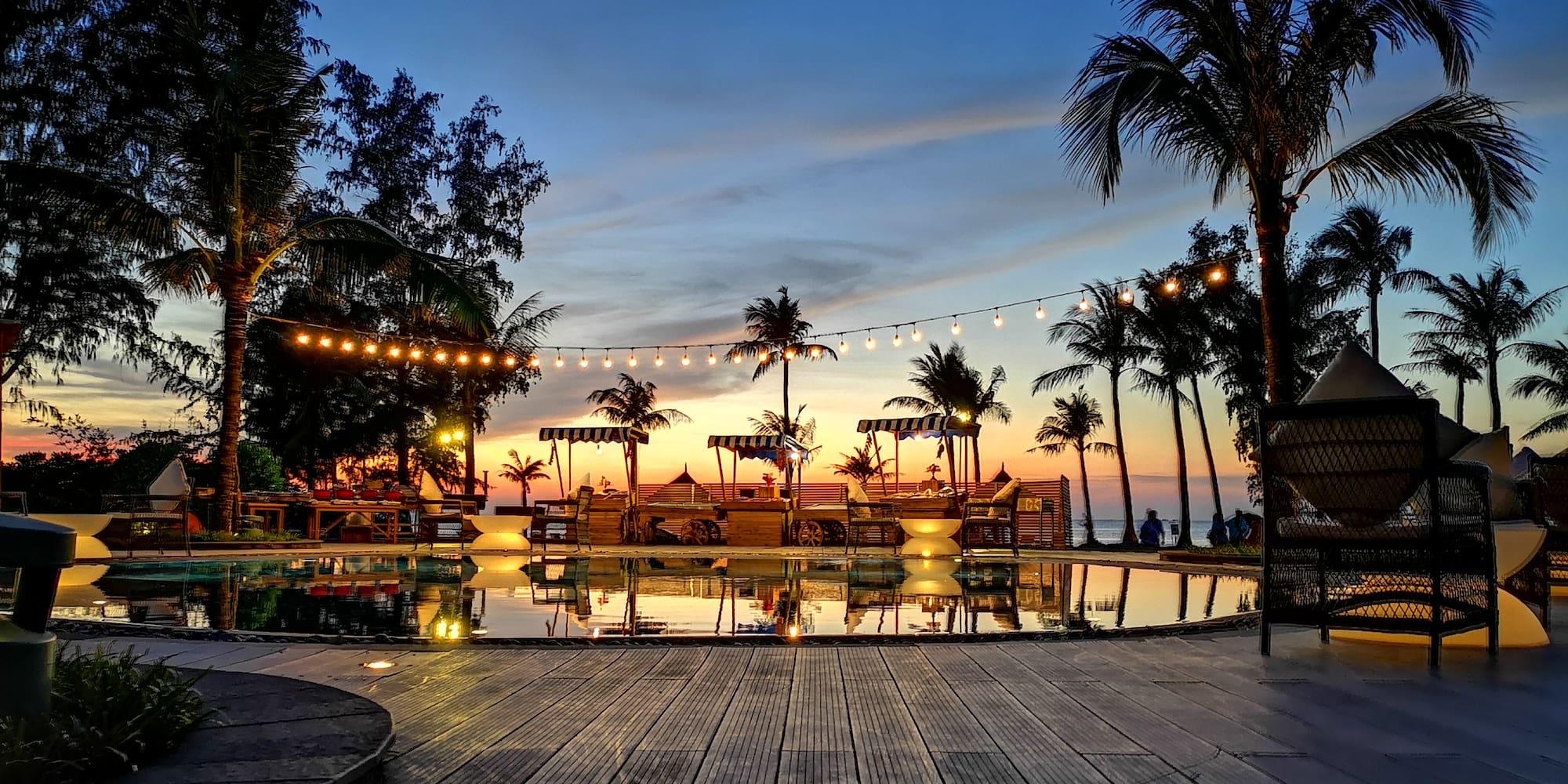 a pool with lights and palm trees