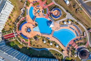 an aerial view of a resort with a pool and a building