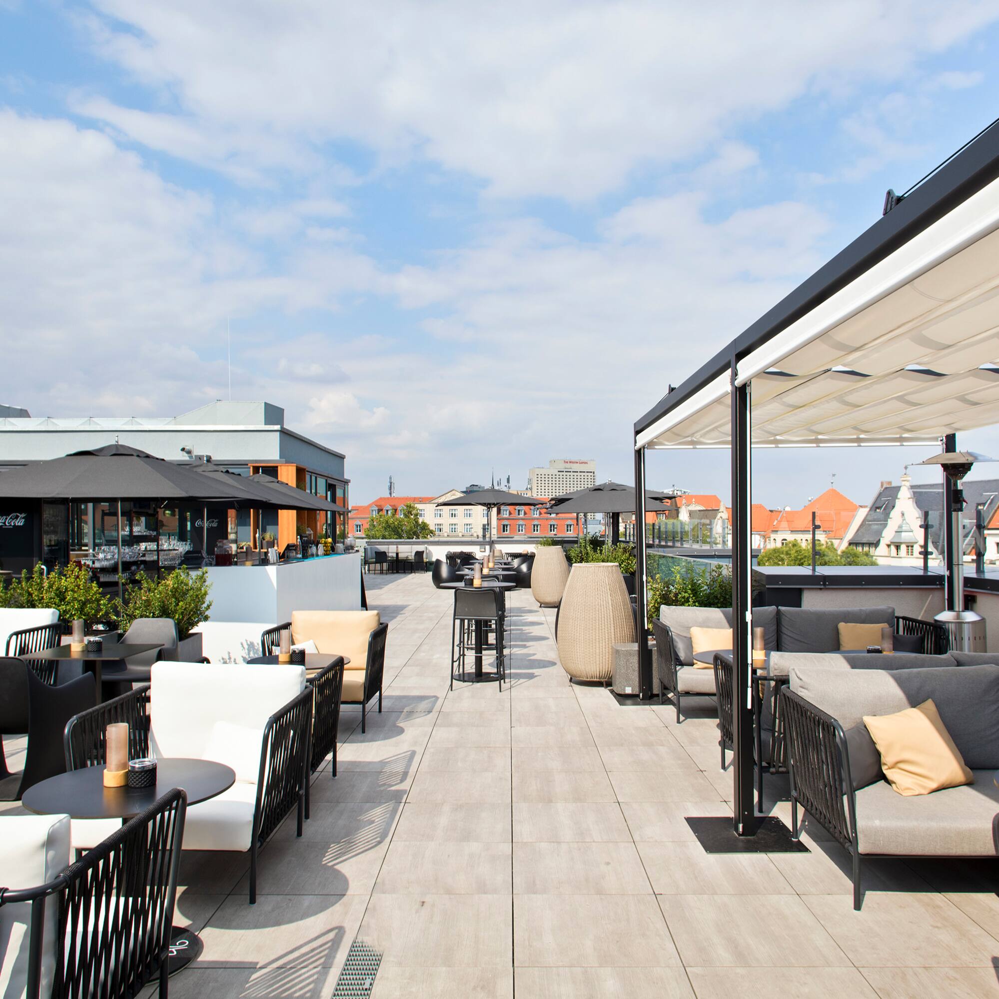 a patio with tables and chairs on a rooftop