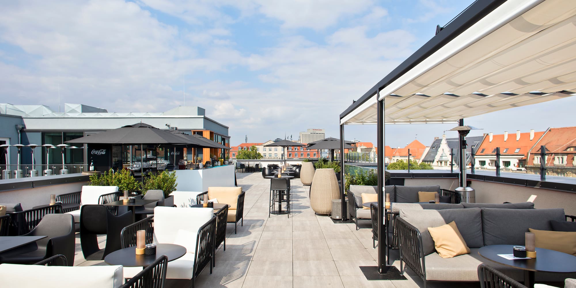 a patio with tables and chairs on a rooftop