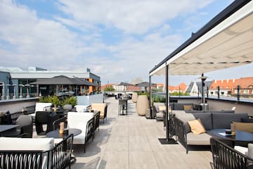 a patio with tables and chairs on a rooftop