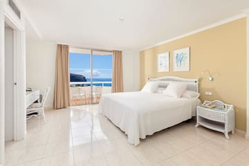 a bedroom with a large window overlooking the ocean